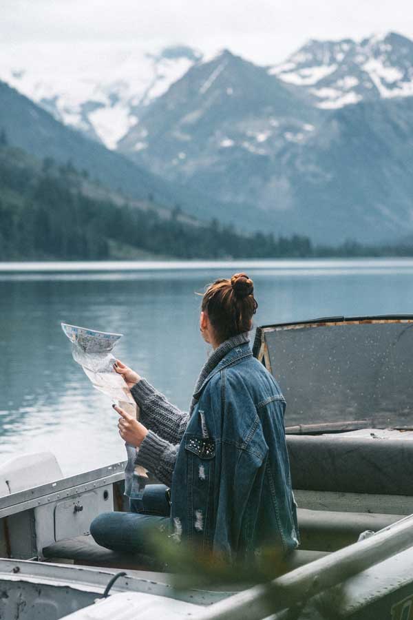 kobieta siedząca na łódce i sprawdzająca mapę